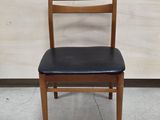 a wooden chair with a black seat and a black seat