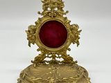 une assiette ancienne en or surmontée d'un verre rouge