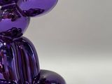 a purple balloon shaped like a bunny sitting on the ground