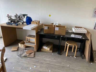 une pièce avec un bureau et beaucoup de cartons par terre