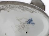 a close up of a plate with a blue flower on it