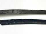 pair of old and worn swords on a white surface