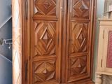 une armoire en bois dans une pièce, à côté d'un meuble en bois