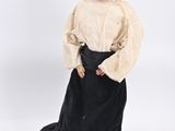 a close up of a doll wearing a black dress and a white shirt