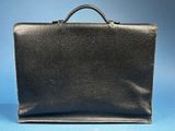 a black briefcase sitting on top of a blue surface