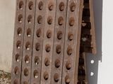 a wooden rack with holes on it next to a white wall