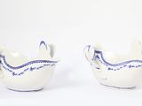 two white bowls with blue designs on them on a white surface