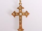 pendentif en forme de croix en or sur fond blanc