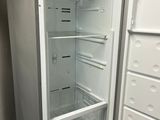 an empty refrigerator in the corner of a kitchen