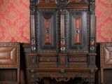 deux chaises et une armoire dans une pièce au papier peint rouge