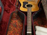 une guitare posée dans son étui, par terre