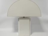a white table lamp with a white shade on top of it
