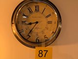 une horloge accrochée au mur, sur laquelle est accrochée une étiquette jaune