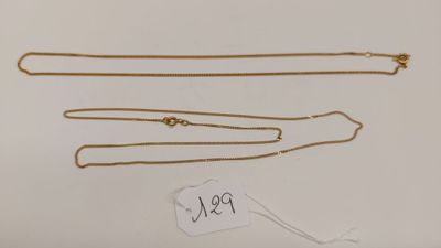 un lot de trois colliers en or avec une étiquette de prix