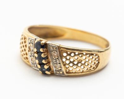 gros plan d'une bague en or avec des diamants noirs et blancs