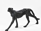 black sculpture of a cheetah on a white background