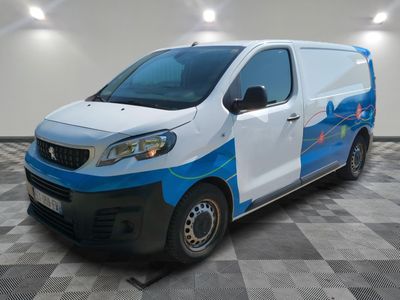 une photo d'une camionnette blanche et bleue garée dans un garage