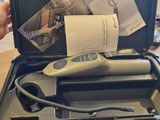 une personne tenant un outil dans un étui posé sur une table
