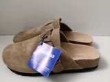 La chaussure est en daim beige et porte une étiquette bleue.