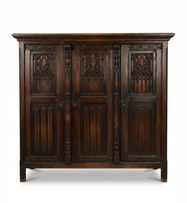 une vieille armoire en bois avec des portes sculptées et une poignée de porte