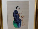 framed picture of a woman sitting on a stool with a painting in the background