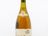 une vieille bouteille de vin posée sur une table blanche