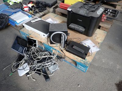 un tas d'appareils électroniques posés sur une palette au sol