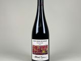 une bouteille de vin rouge posée sur une table blanche