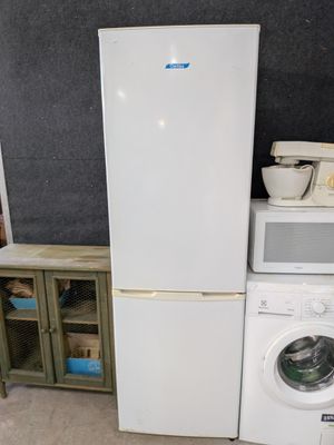 un réfrigérateur blanc à côté d'une machine à laver dans une pièce