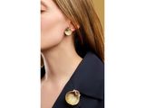 a woman wearing a black jacket and gold earrings
