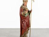 a statue of a man holding a cane and wearing a red robe