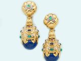 two pairs of earrings with blue and green stones on a white surface
