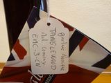 a person holding a bottle of wine with a tag attached to it