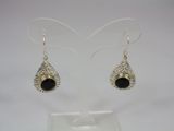 a pair of silver earrings with black stones on them