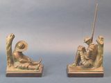 two figurines of a man and a woman sitting on a bench