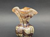 a brown and white vase sitting on a table