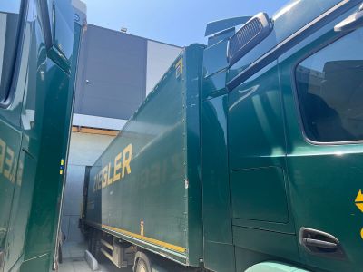 a green truck that is parked next to another truck