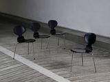 four black chairs sitting in a row in a room