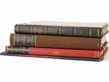 three books stacked on top of each other on a white surface