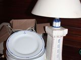 une table sur laquelle se trouvent une lampe, des assiettes et une lampe