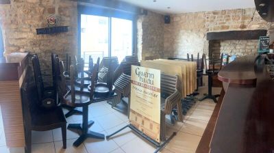 des tables et des chaises dans une pièce dotée d'un mur en pierre et d'une cheminée