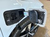 a white car that is charging at a gas station
