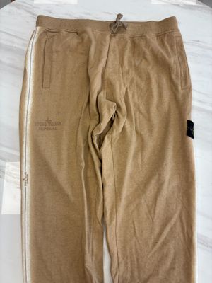 a pair of brown sweat pants sitting on top of a bed