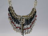 beaded necklace with red, white, and black beads on a metal stand