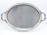 an oval silver tray with handles and handles on a stand