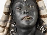a statue of a woman with black paint on her face