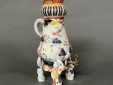 une théière en porcelaine avec un couvercle, posée sur un socle