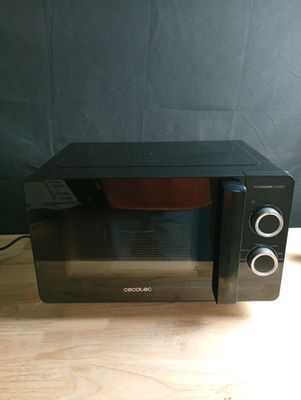 un micro-ondes posé sur une table, avec un bol à l'intérieur