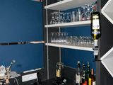 a wine rack with wine glasses on it in the corner of a room