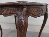 a wooden table with carvings on the top of it